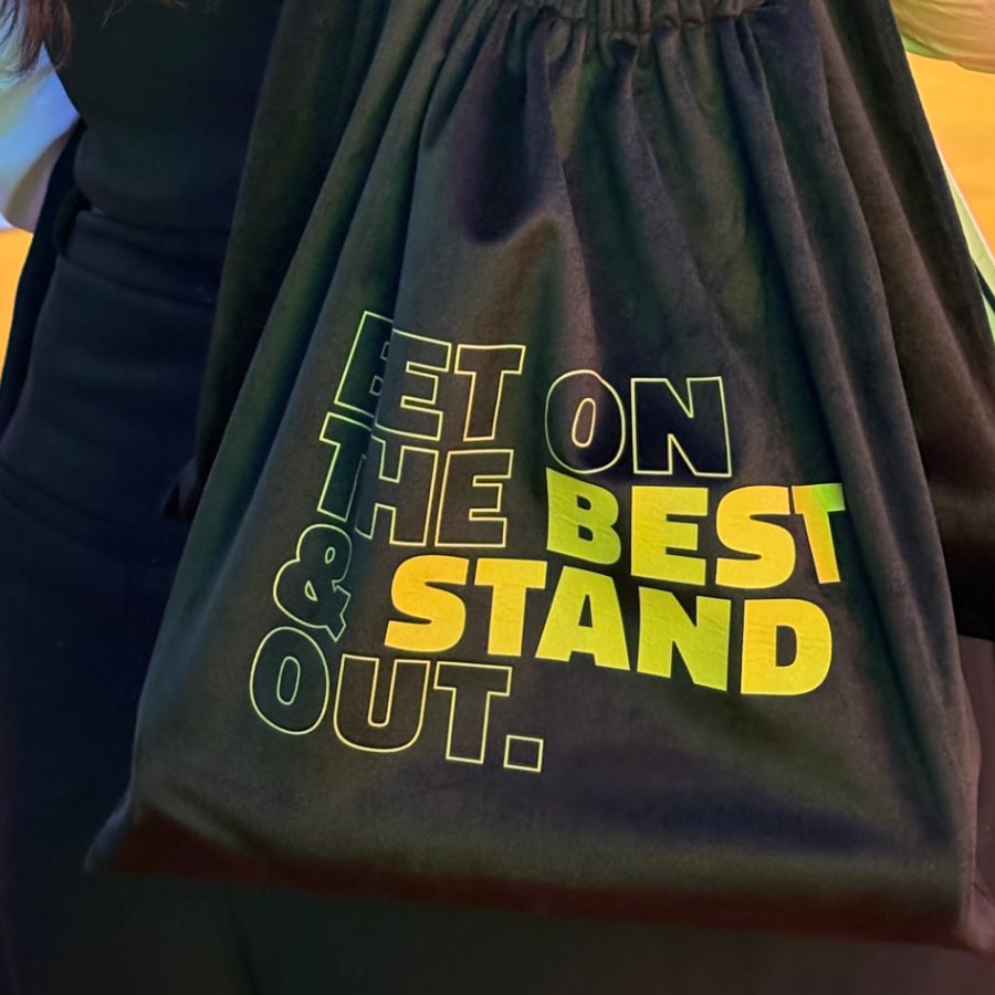 NUUK branded tote bag with 'Get on the best & stand out' print at a trade show